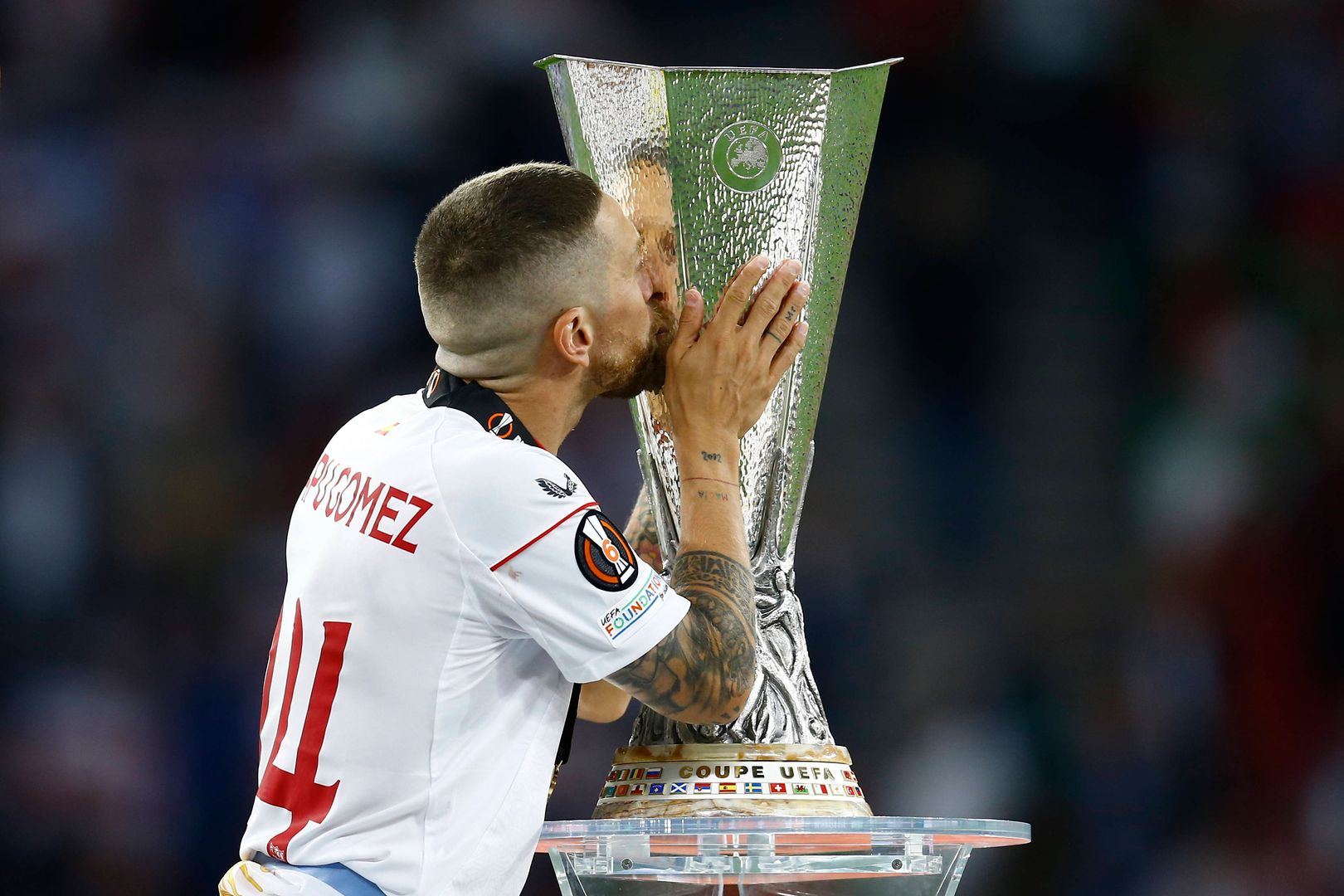 Алехандро Дарио Папу Гомес из «Севильи» целует трофей во время матча Лиги Европы УЕФА