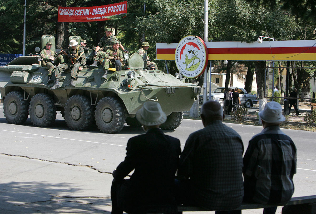 Российские солдаты едут под плакатом 