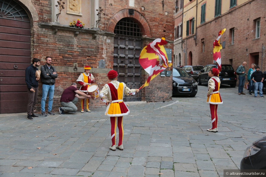 Мальчишки в красочных костюмах тренируются при подготовке к празднику Палио.