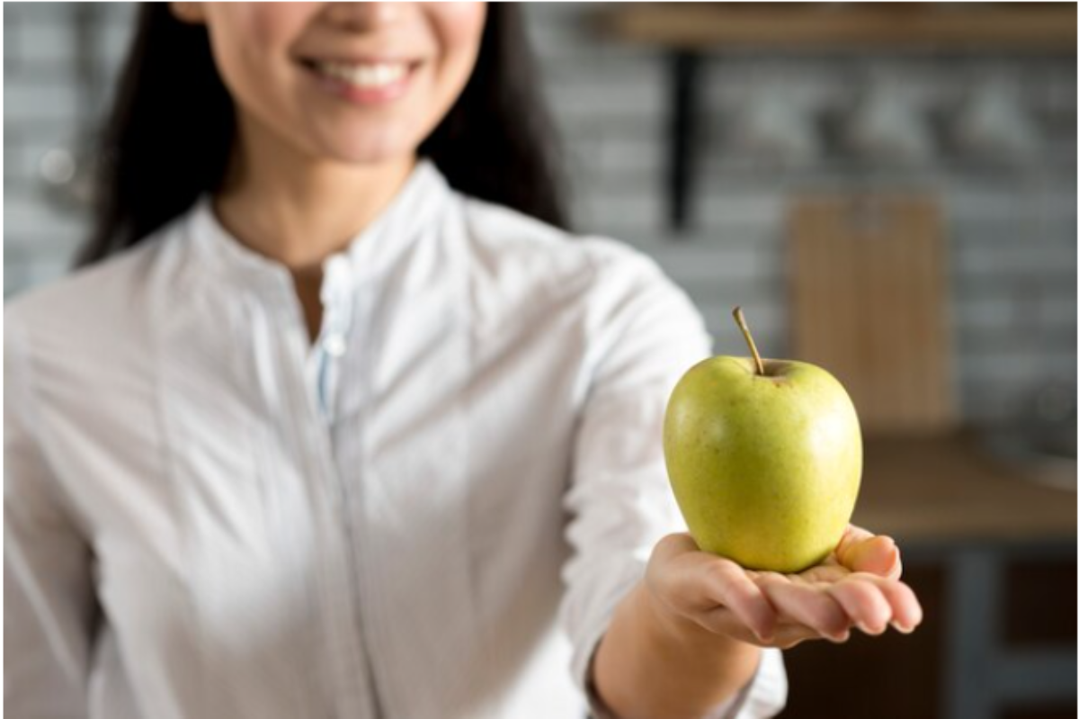 Apple only. Яблоко здоровья. Зеленое яблоко в женской руке. Чем полезны яблоки для женщин.