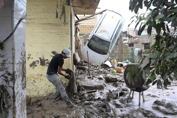 Мужчина убирает грязь в одной из пострадавших от дождей областей в Мексике. По меньшей мере 64 человека погибли во время бедствия - Sputnik Абхазия