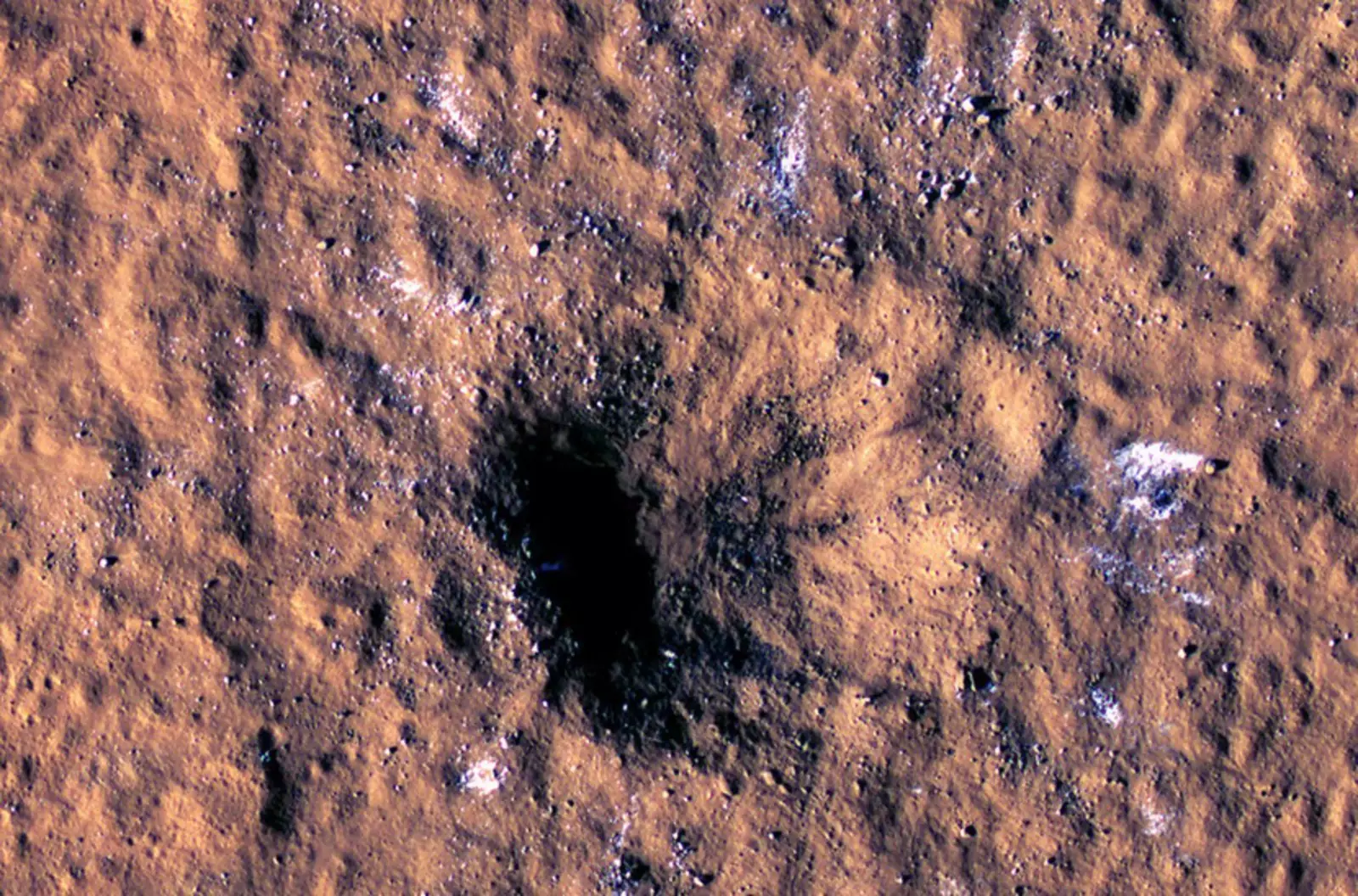 Новый ударный кратер, вид с орбитального аппарата Mars Reconnaissance Orbiter. Белые пятна обозначают куски водяного льда, выброшенные из-под поверхности.