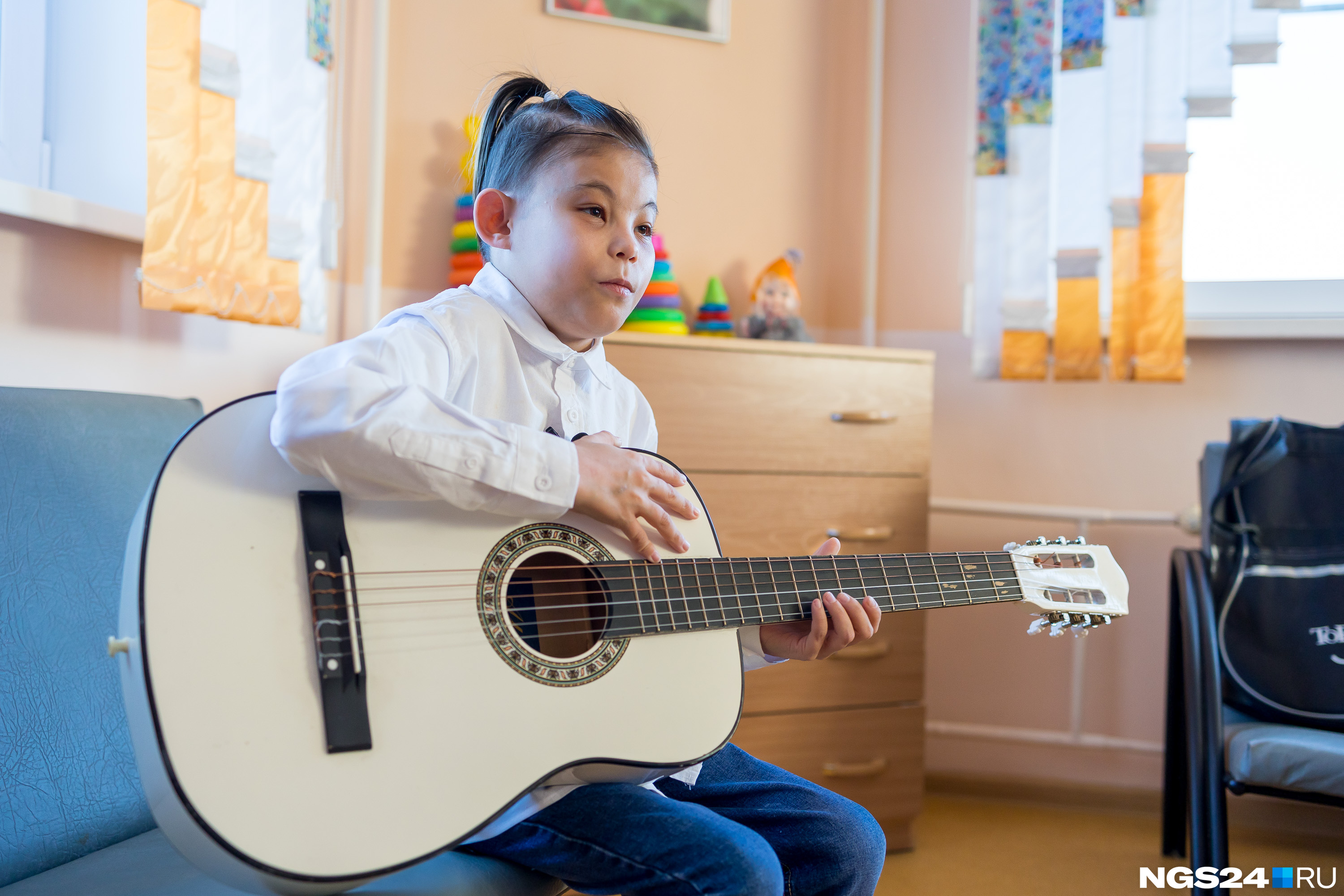 Волонтер Сардана купила Вове гитару и учит его играть на ней