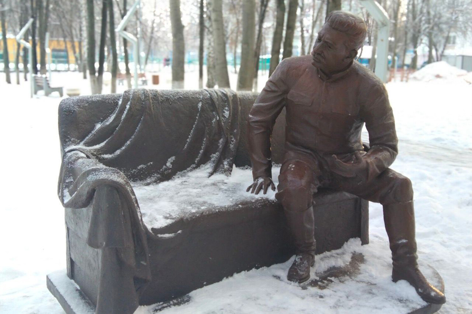 Памятник сидит на скамейке