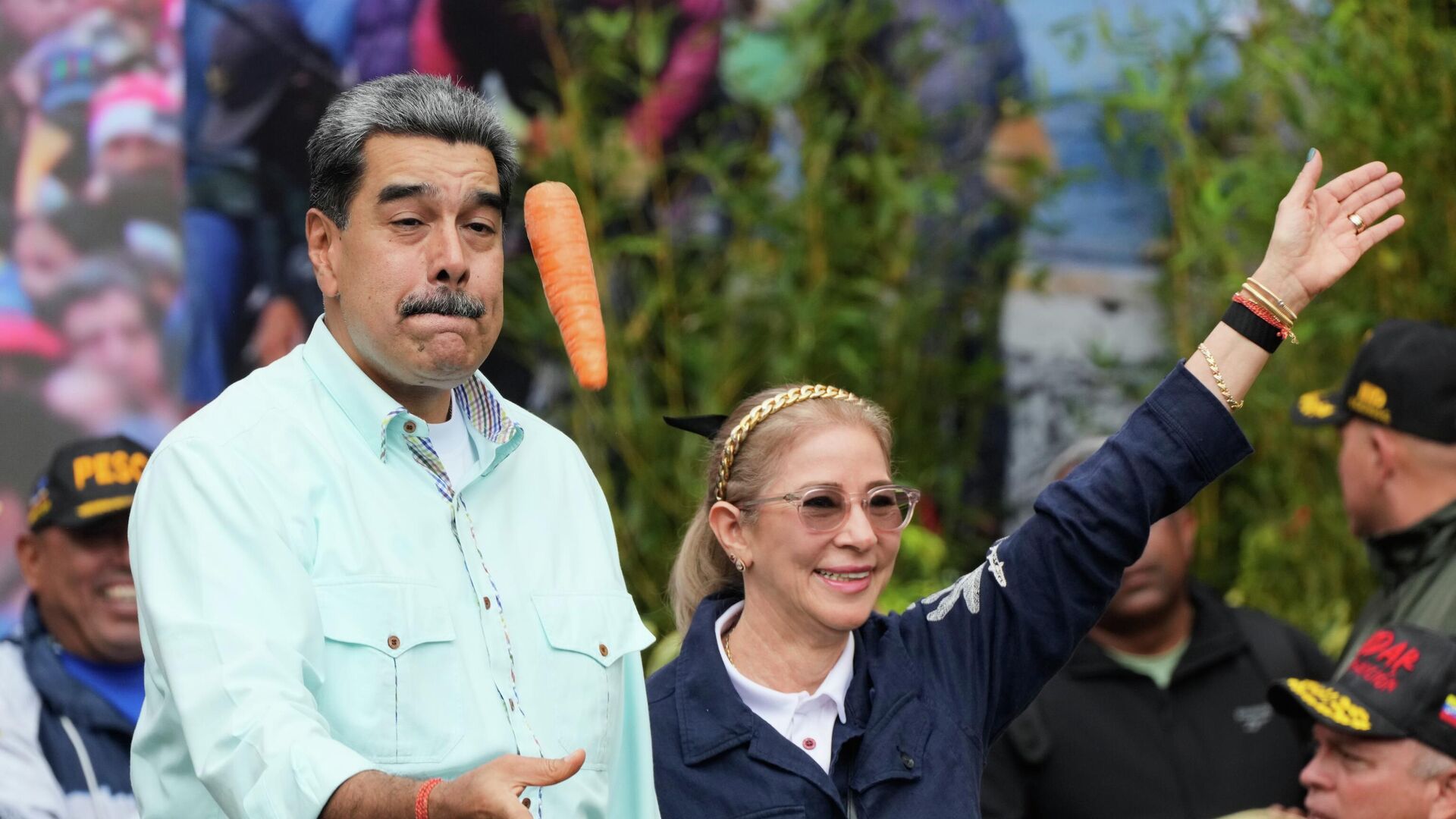 Президент Николас Мадуро бросает морковку рядом со своей женой Силией Флорес во время митинга в Каракасе, Венесуэла - Sputnik Грузия, 1920, 06.01.2026