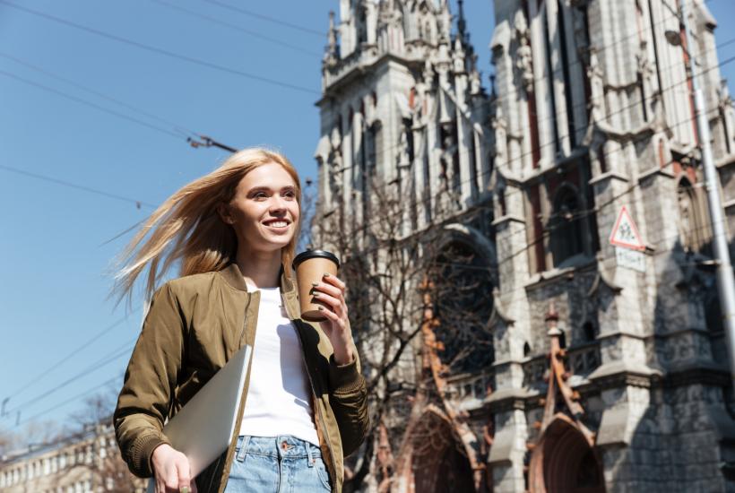 Молодая женщина с ноутбуком и кофе