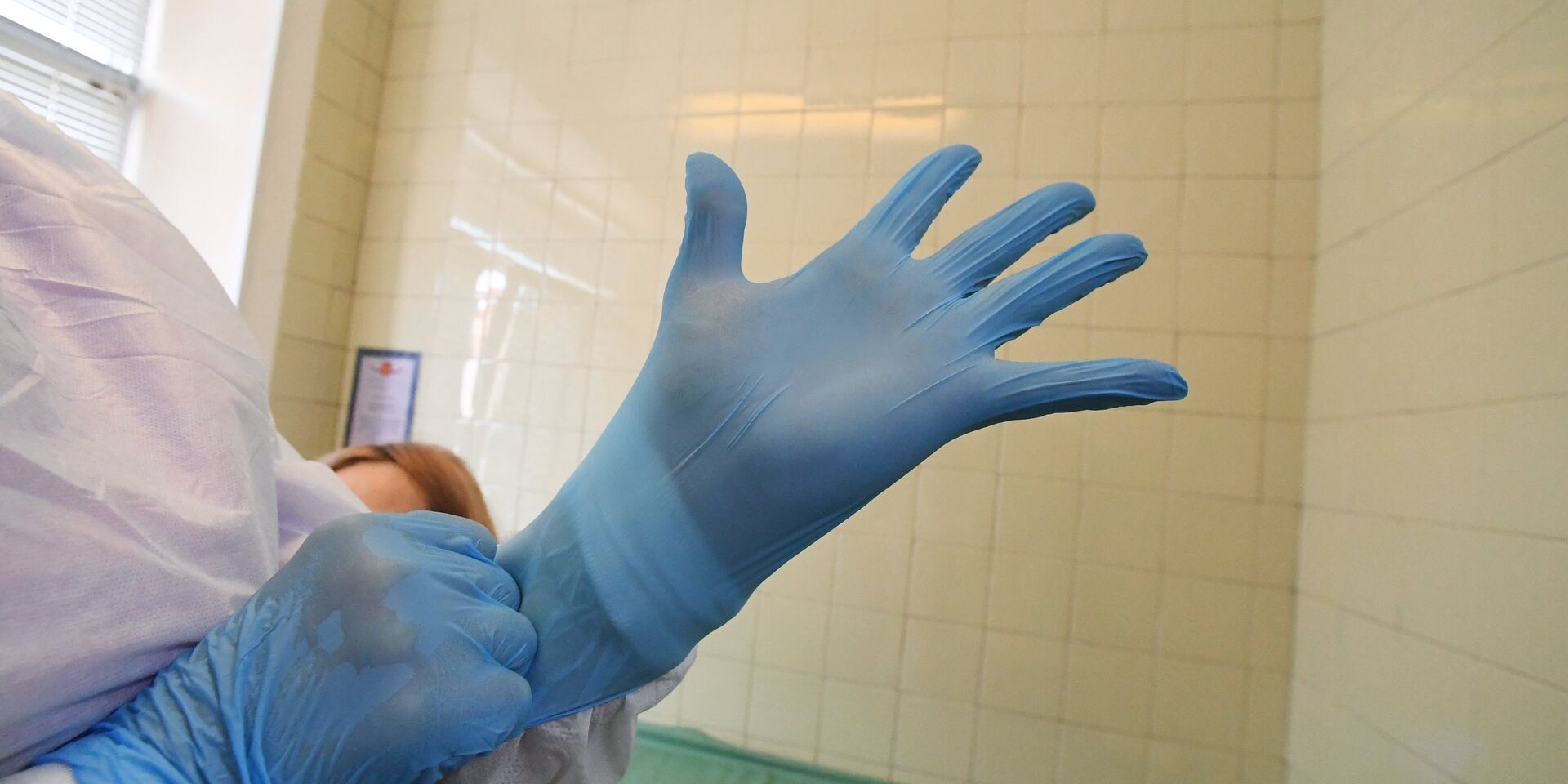 Врач надевает перчатки перед приемом пациентов - ИноСМИ, 1920, 26.11.2025