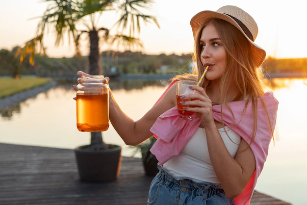 Front view woman with delicious kombucha outdoors