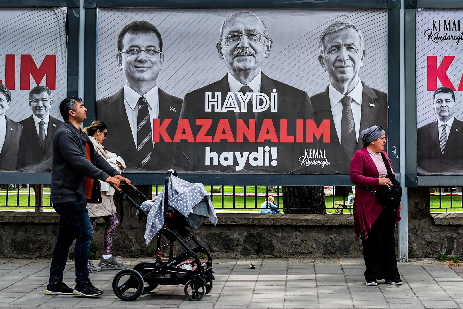 Люди проходят мимо плакатов с изображением Кемаля Киличдароглу, мэра Стамбула Экрема Имамоглу и мэра Анкары Мансура Явы. 2023