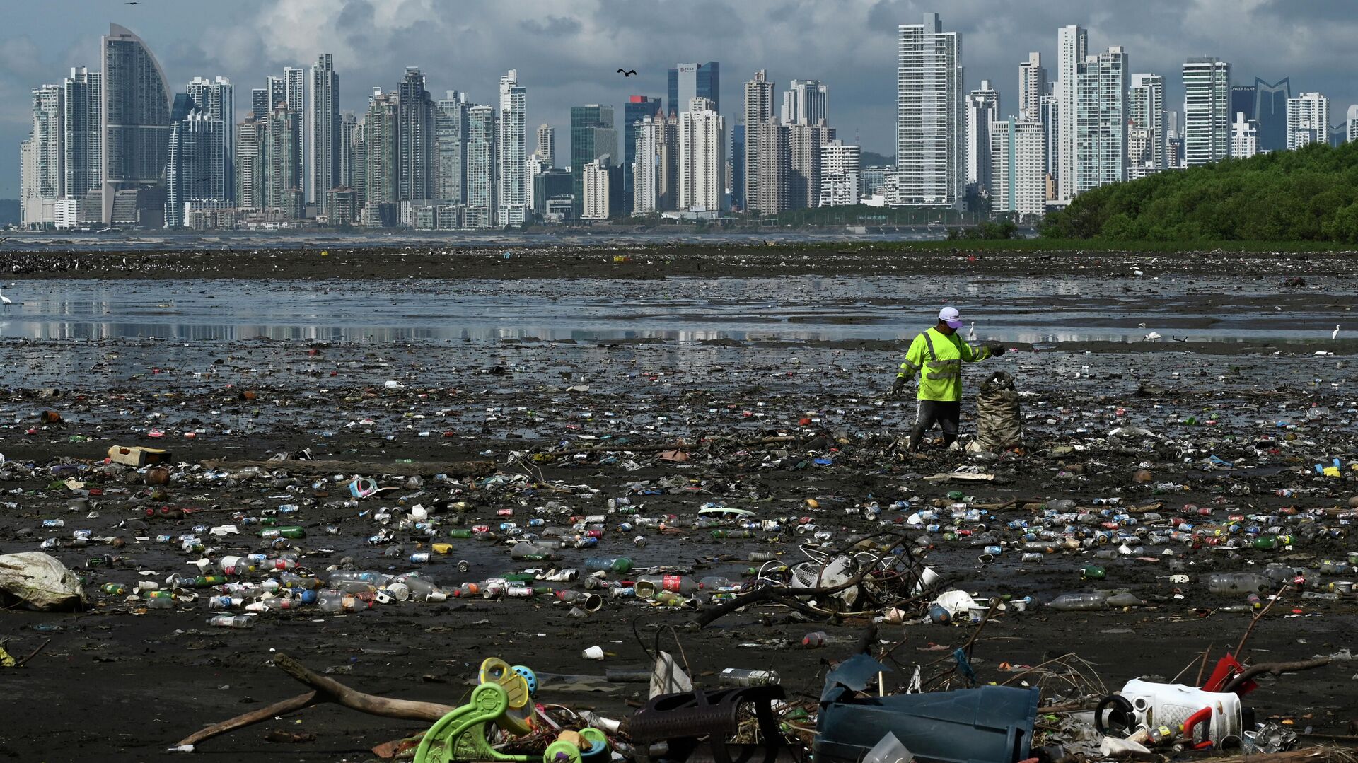 Мужчина собирает мусор, включая пластиковые отходы, на пляже Коста-дель-Эсте, в Панама-Сити, 19 апреля 2021 года - Sputnik Азербайджан, 1920, 07.06.2023