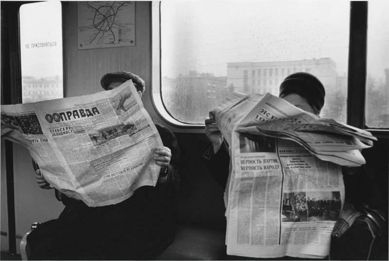 Люди изучают последние новости в вагоне московского метро, 1970 год