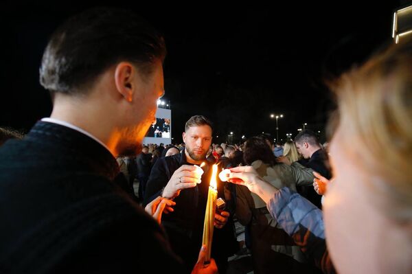 Верующие делятся частицей Благодатного огня перед Кафедральным собором в Кишиневе, 19.04.2025 - Sputnik Молдова