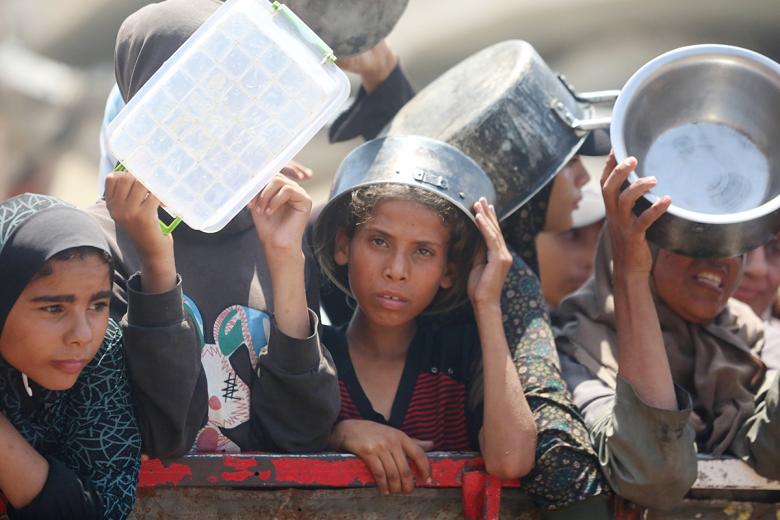 Палестинцы ждут, чтобы получить еду из благотворительной столовой