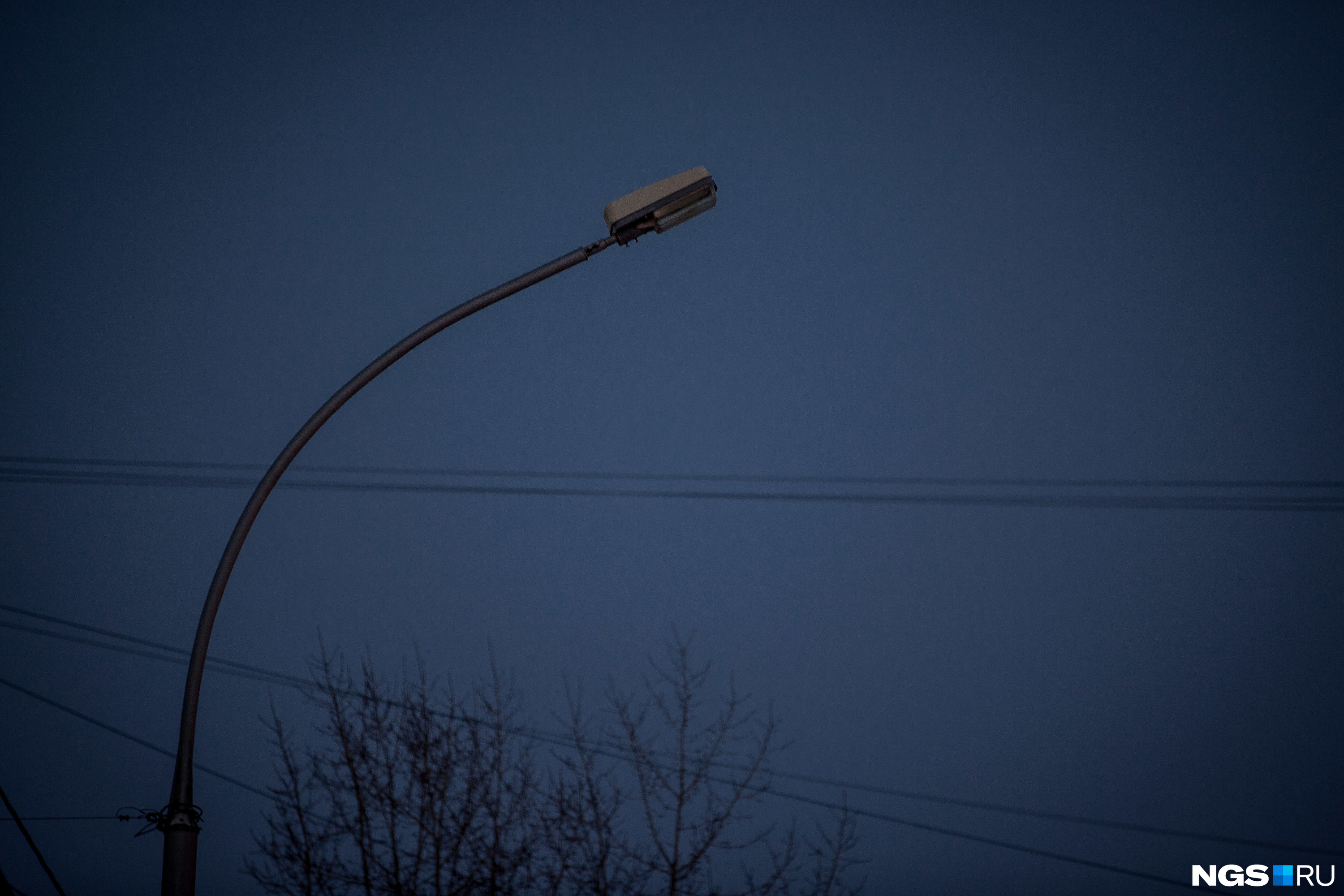 Отключили свет новосибирск. Выключение уличных фонарей. Горит фонарь уличного освещения. Уличный фонарь в темноте. Фонарный столб на дороге.
