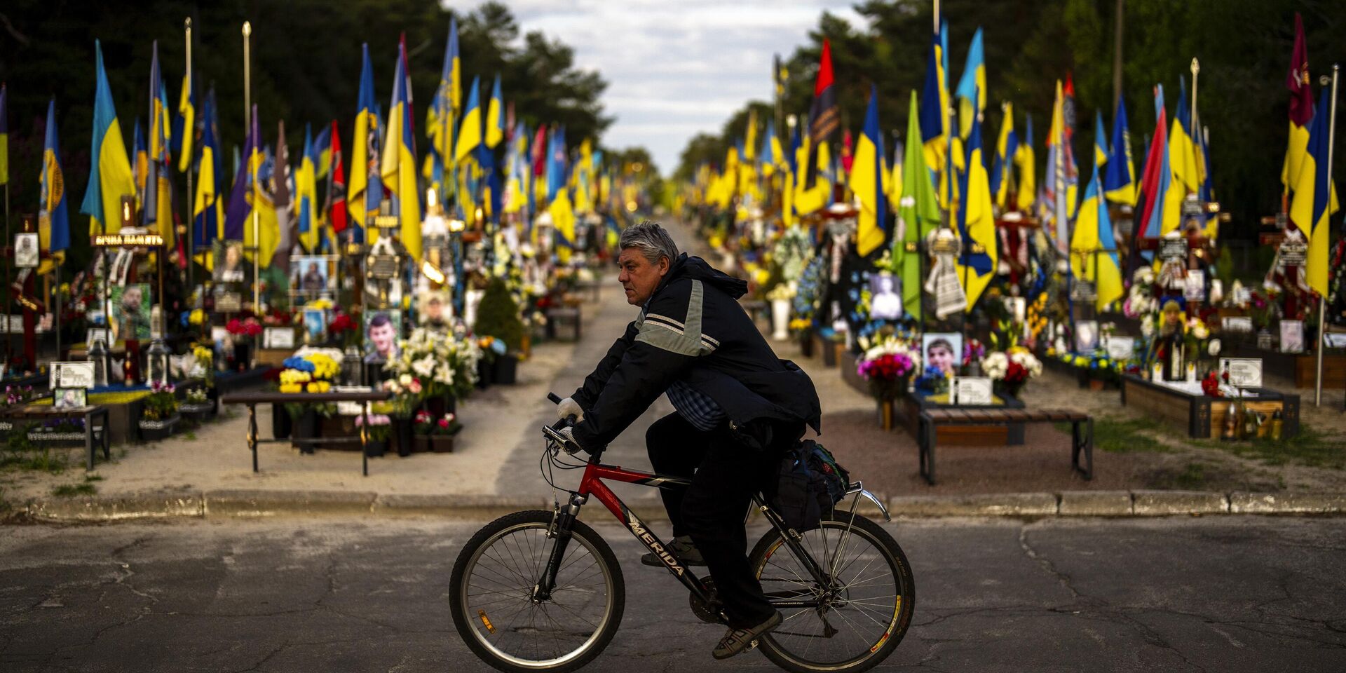 Велосипедист проезжает мимо могил украинских солдат, погибших во время боевых действий, на Лесном кладбище в Киеве - ИноСМИ, 1920, 09.12.2024