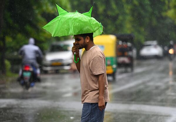 Пассажиры во время утреннего дождя в Нойде, Индия - Sputnik Грузия
