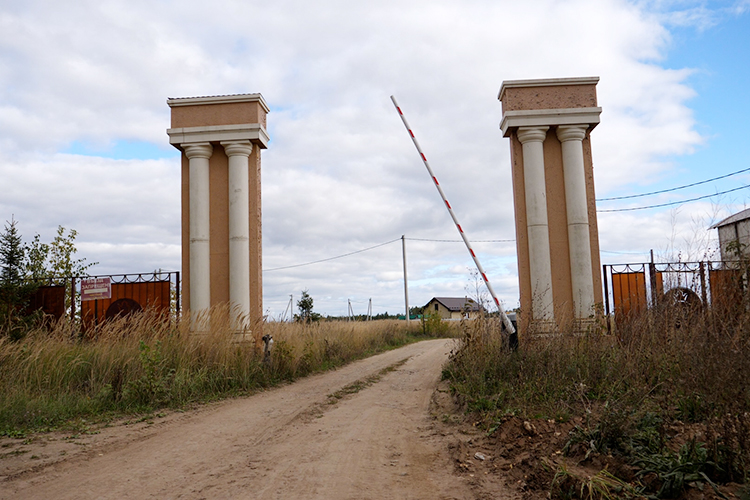 На въезде в «Резиденцию» стоят два широких «верстовых» столба, которые появились здесь еще в 2017-м, будка охранника (без охранника) и открытый шлагбаум