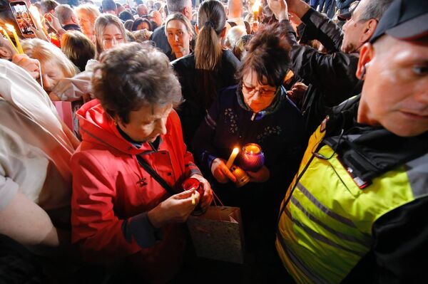 Верующие делятся частицей Благодатного огня перед Кафедральным собором в Кишиневе, 19.04.2025 - Sputnik Молдова