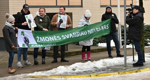 Сотрудники завода азотных удобрений Achema держат плакат с надписью «Люди важнее прибыли» во время акции протеста