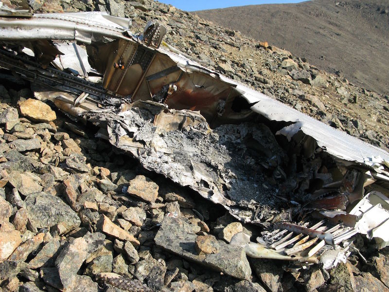 Части разбившегося самолета разбросаны на сотни метров по поверхности склона