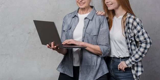 Portrait of female friends browsing a laptop