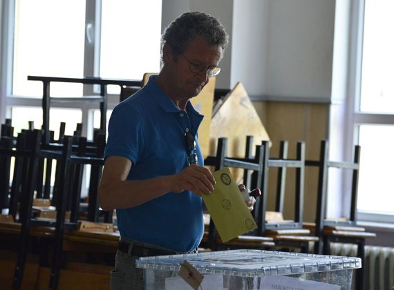 Мужчина опускает бюллетень в урну на одном из избирательных участков в Анкаре