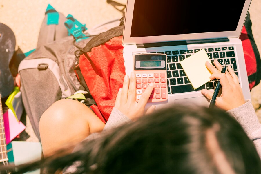 woman-taking-notes-by-hand-with-calculator-laptop-sunny-day_23-2148154889.jpg