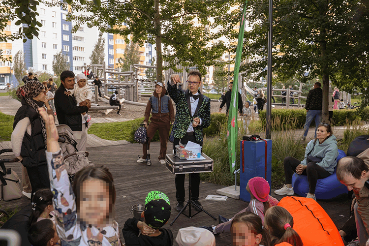 Неподалеку в тени деревьев фокусник демонстрировал свое искусство. Он не просто показывал фокусы — он вовлекал детей в удивительное представление, делая их активными участниками магического действа