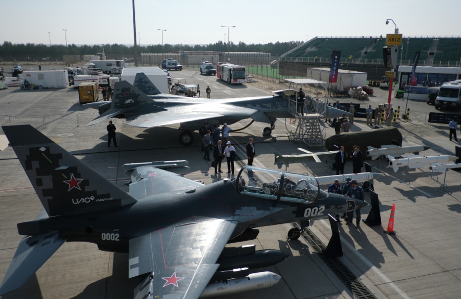Учебно-боевой самолет Як-130М и российский истребитель Су-57Э (на дальнем плане) на Международном авиационно-космическом салоне Dubai Airshow-2025 в Дубае