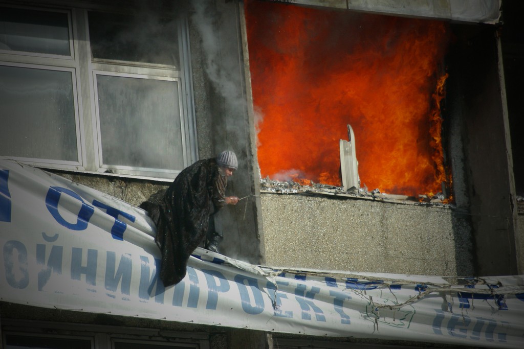 В окнах полыхал огонь, женщины пытались удержаться на рекламных растяжках