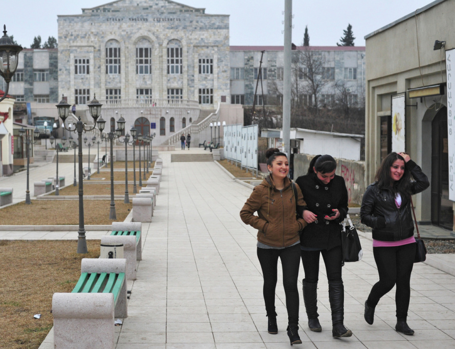 Девушки идут по аллее у здания Карабахского университета