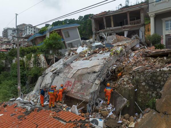 Спасатели работают на месте оползня, вызванного дождем, в деревне Даяуан, Китай. Они извлекли девять человек из завалов, двое из которых были подтверждены погибшими, после того как оползень, вызванный дождем, заблокировал 14 человек - Sputnik Абхазия
