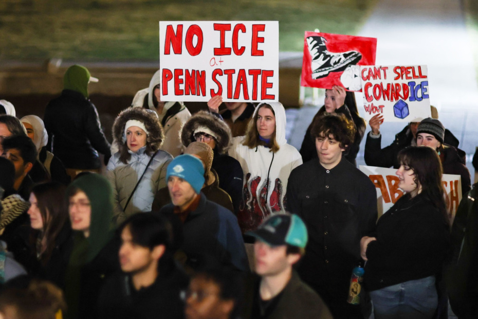 Демонстранты держат плакаты перед зданием Old Main Университета штата Пенсильвания во время протеста против Службы иммиграции и таможенного контроля США (ICE). Протест был организован Студенческим комитетом защиты и солидарности в ответ на убийство агентом ICE Рене Николь Гуд в Миннеаполисе