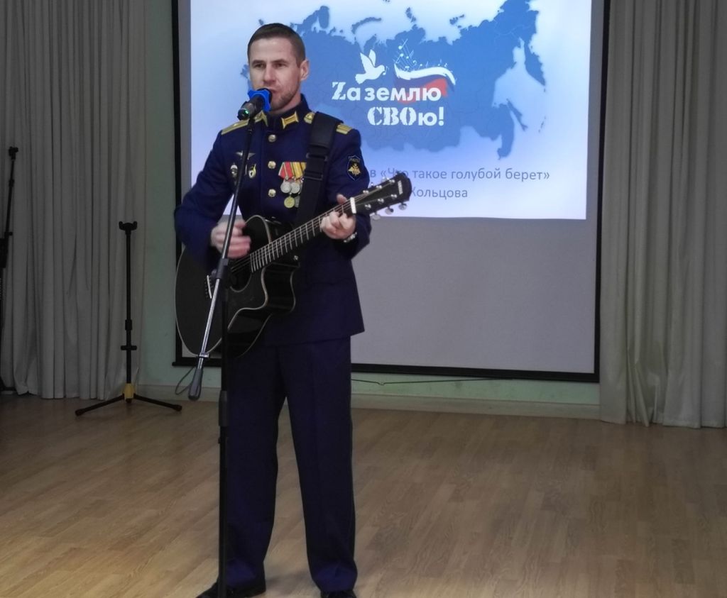 На сцене - мужчина в военной форме с гитарой
