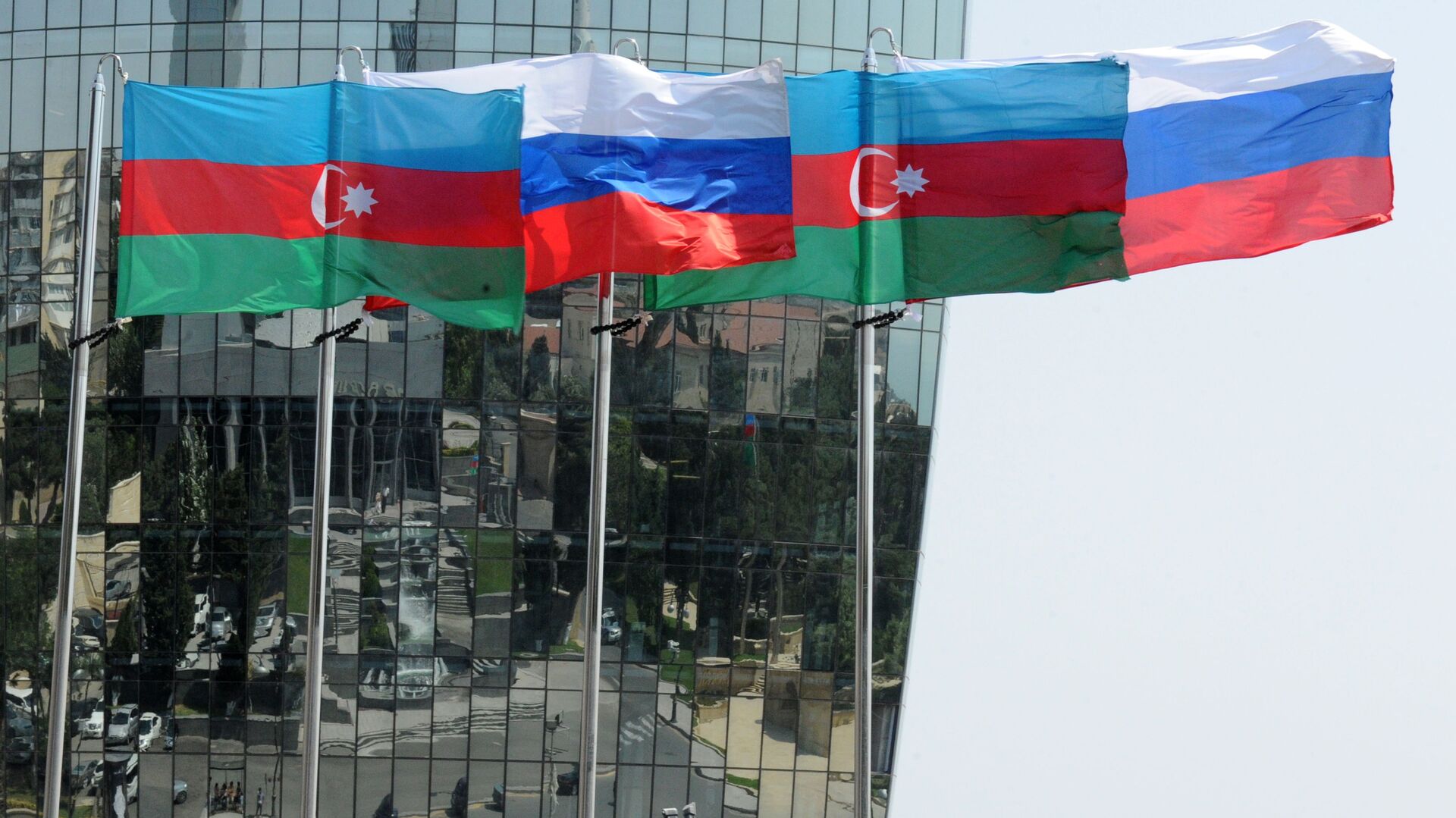 Национальные флаги России и Азербайджана на фоне фасада одной из башен Башни Пламени (Flame Towers) в Баку - Sputnik Азербайджан, 1920, 22.06.2025