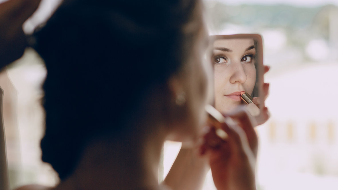 Девушка наносит блеск на губы