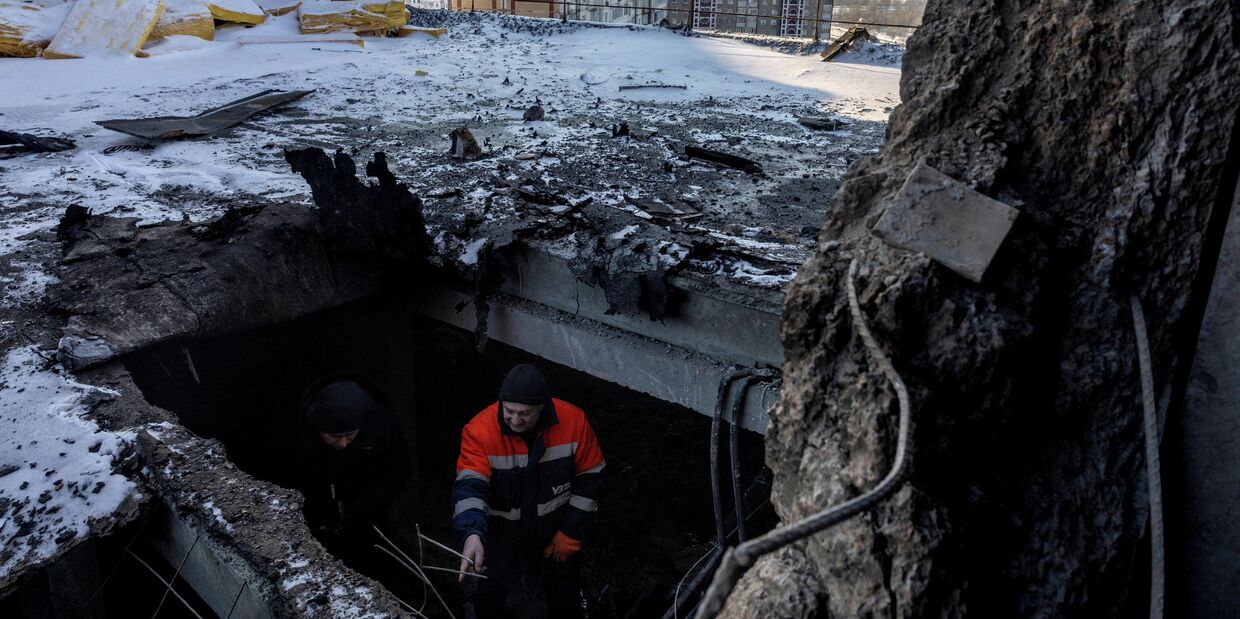 Киевлянин показывает журналисту место удара российского беспилотника