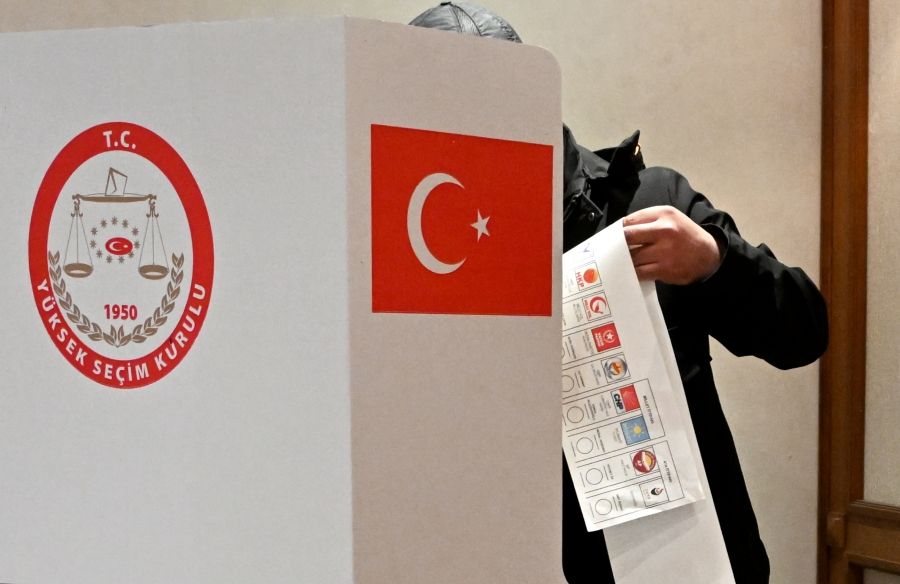 Избиратель с бюллетенем со списком партий на выборах в Турции