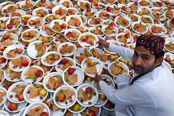 Волонтер готовит ифтар для верующих-мусульман перед разговением в храме Дата Дарбар, Лахор, Пакистан. - Sputnik Азербайджан