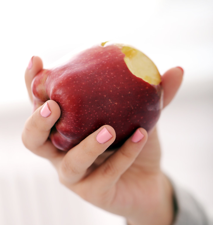 Укус яблока. Фото красного яблока в холеных женских руках. Apple in hand. Рука яблоко необычное фото.