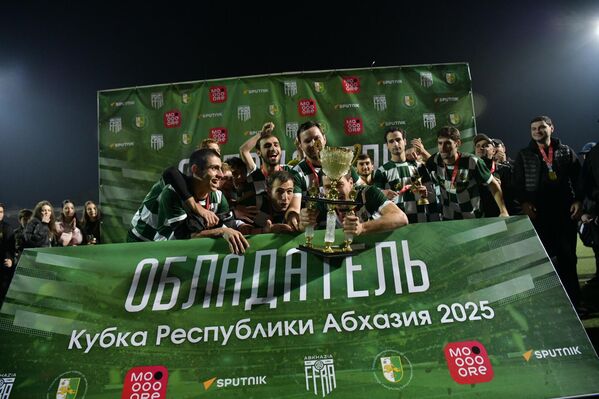 Радостные футболисты "Нарта" фотографируются с трофеем в руках. - Sputnik Абхазия