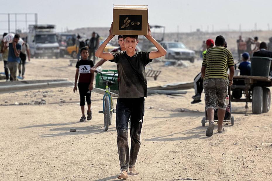 Палестинские вынужденные переселенцы, страдающие от нехватки продовольствия, собираются у пункта раздачи гуманитарной помощи в коридоре Нецарим