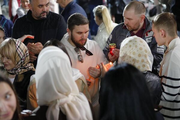 Верующие делятся частицей Благодатного огня перед Кафедральным собором в Кишиневе, 19.04.2025 - Sputnik Молдова