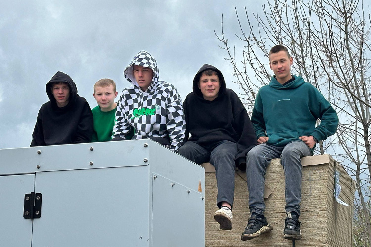 На выгрузке мы познакомились с 15-летним Антоном. Он был весел, попросил сфотографировать, как он с пацанами сидит на пачках фанеры