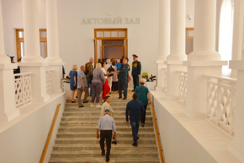 В актовый зал по парадной лестнице.