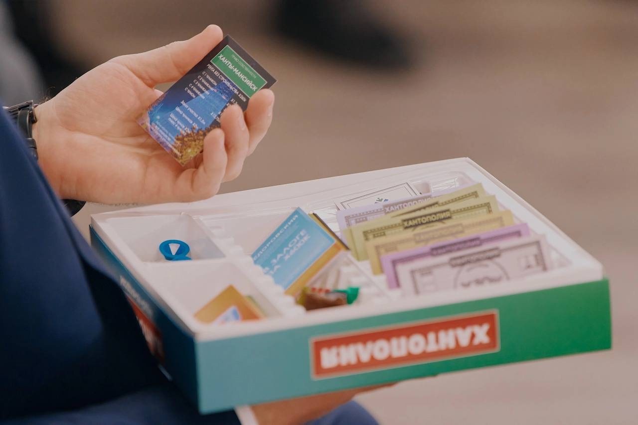 На фотографии изображен мужчина, держащий в руке карточку собственности 