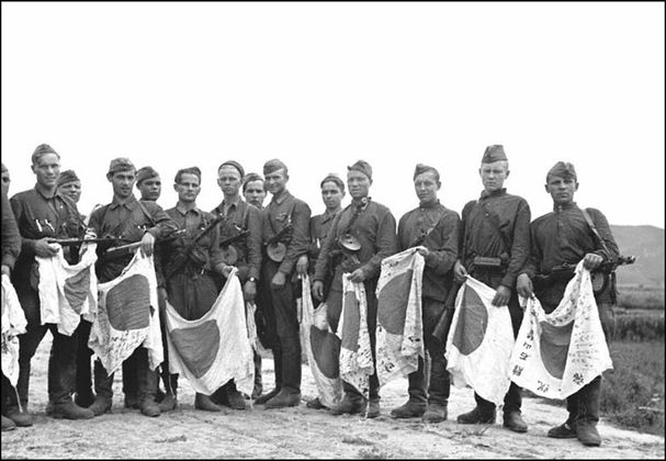Советские солдаты с трофейными японскими флагами. Август 1945