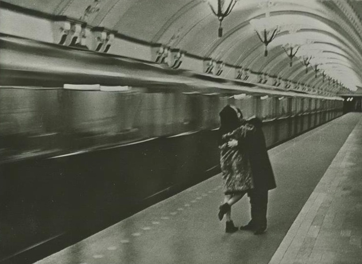 Влюбленная парочка на фоне прибывающего поезда. 1970-е